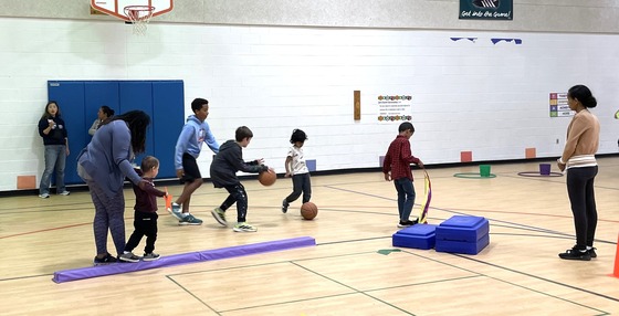 Students using fitness equipment with help from friends and teachers