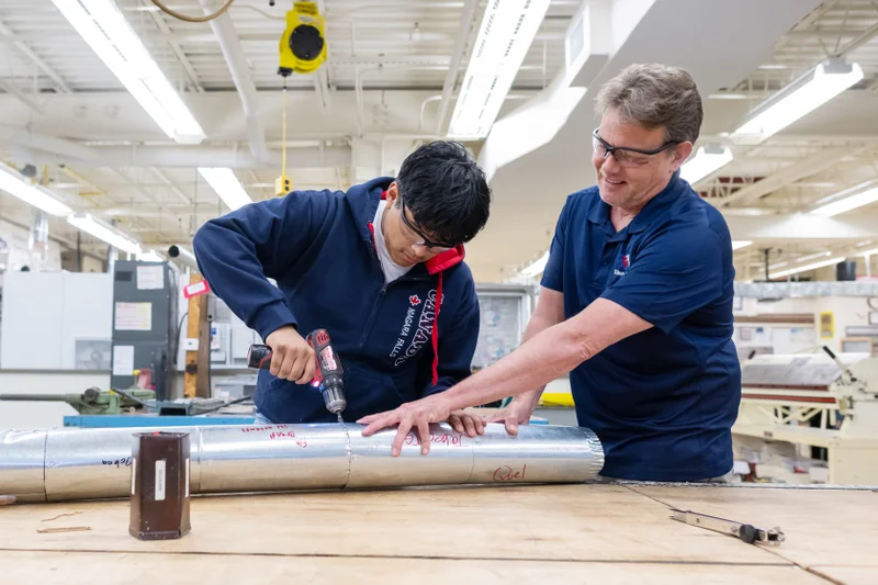 teacher assisting student in HVAC class
