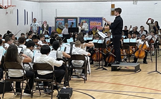 4th grade strings students playing in their concert in the gym
