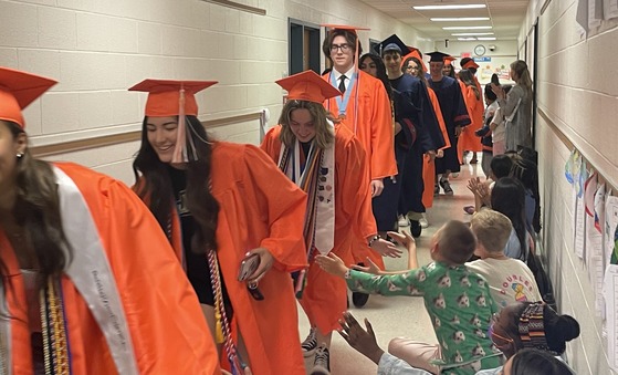 Class of 2025 graduates walking the hallways to cheers and applause from students and staff