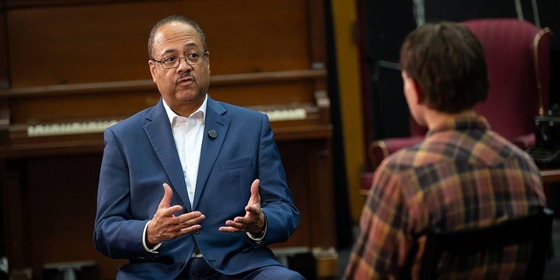 man speaking to another person in a seated interview
