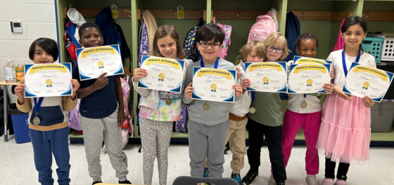 HMES students holding their perfect attendance award certificates.