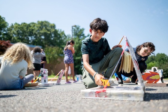 students working on their solar ovens on a blacktop
