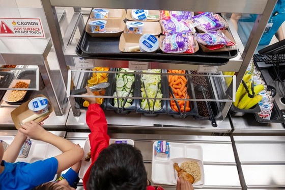 students going through a lunch line looking at healthy foods