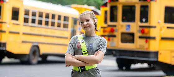 student smiles with their patrol belt on