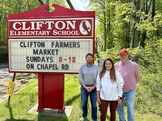 Kyle McDaniel in front of the Clifton School Sign
