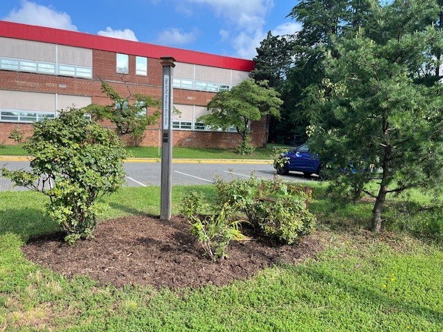 A wooden pole stands in a quiet area in front of Weyanoke Elementary School. Our Peace Pole is where we honor those we have lost as a community.