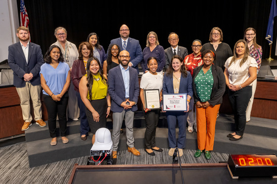 Navy Federal staff hold honor roll certificate amongst FCPS staff and School Board members
