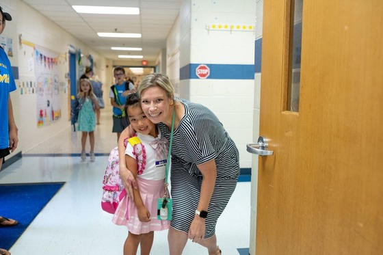teacher smiling with student in the school hallway