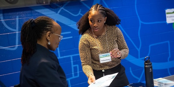 two people talking with a paper in-between them