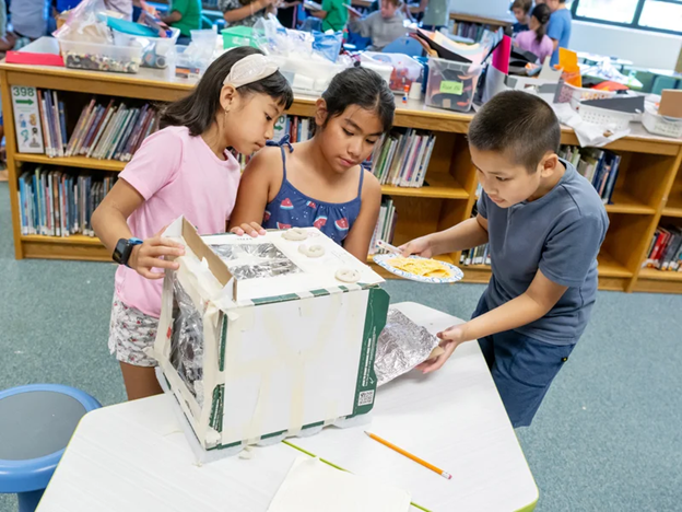 Students working together to build cardboard oven