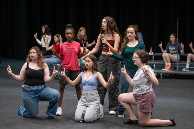 Students practicing performance on stage