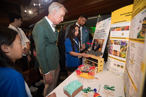 Students and adults looking at Electro-Buzz display