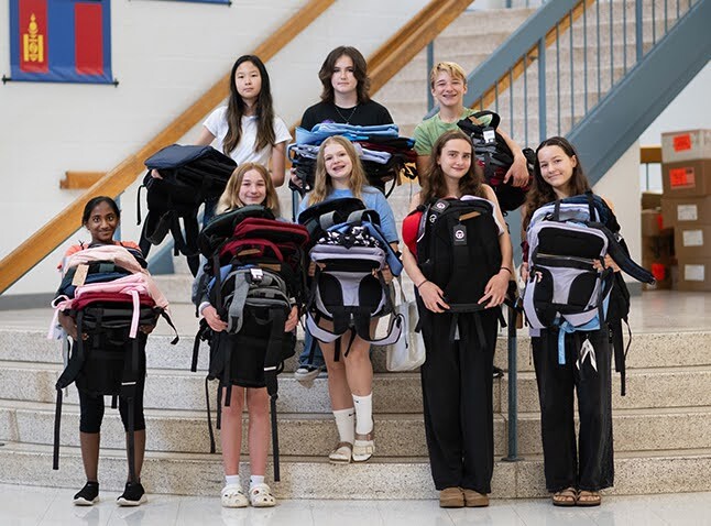 students holding backpacks
