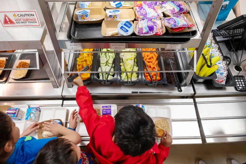 student in a lunch line looking at healthy foods