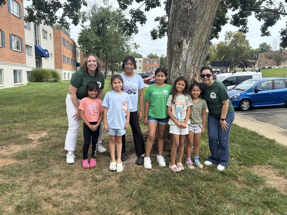 Two teachers stand with students 