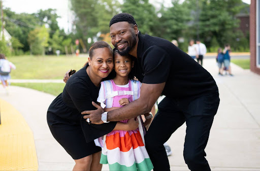 parents hug their daughter