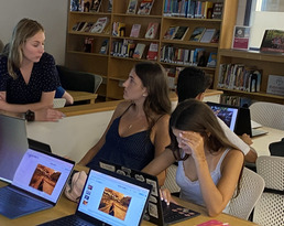 students and teacher discussing in a library