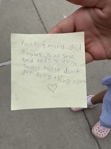 Post it with the words  "Your feeling good about yourself, and ready to learn. Smart people don't get everything right." 