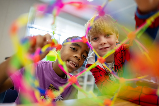 Students look through a hoberman sphere/breathing ball. 
