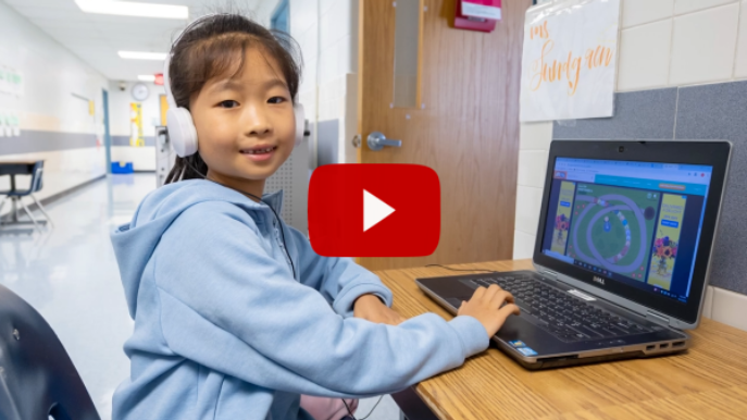 Screenshot of a video with a play button featuring a student on a laptop