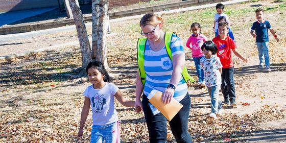 student walks with her teacher outside during a fire drill