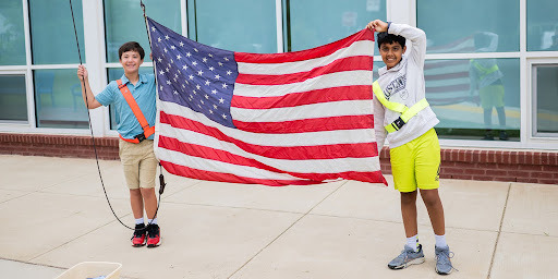 Two students hold up an American flag