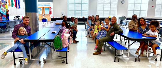 Parents and children sitting at cafeteria tables
