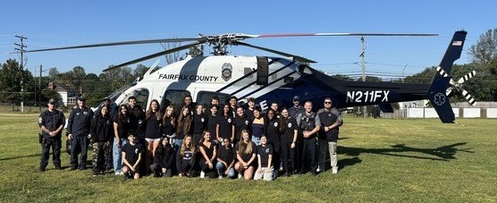 Students and police officers stand in front of helicopter