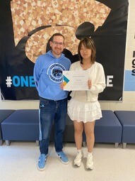Student holding certificate standing beside principal