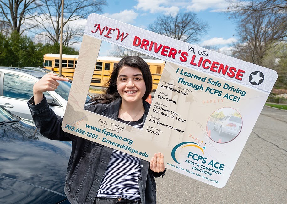 student smiles and holds up their bus pass