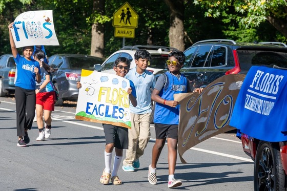 students walk in parade holding signs