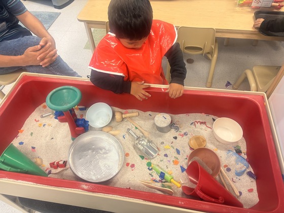 Student plays in sensory sand box 