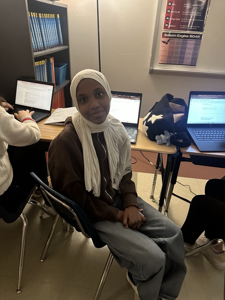 a student sitting in a classroom with a computer