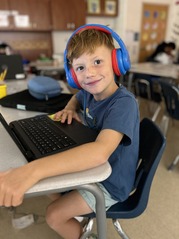 student wearing headphones on a computer