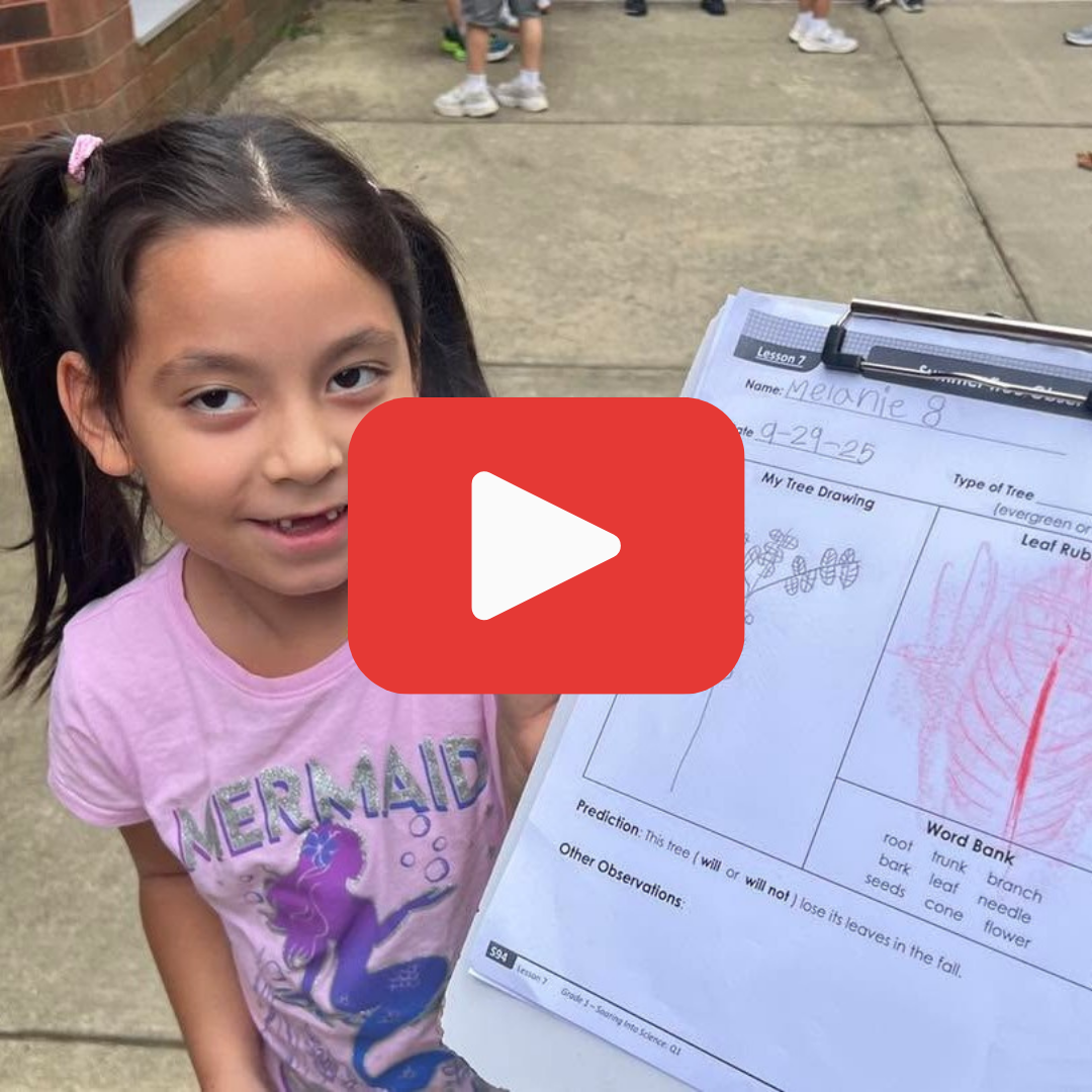 A young girl holding a clipboard while standing outside