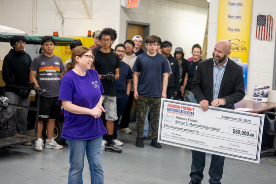 teacher is awarded large check in front of her peers