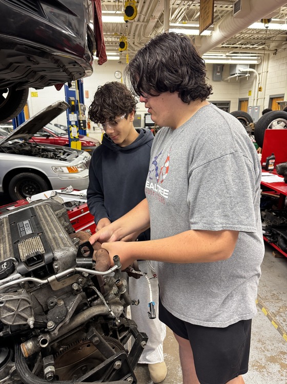 students working on car parts
