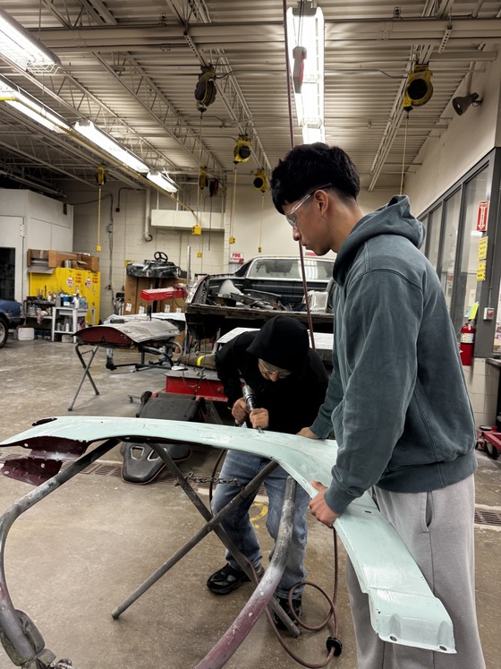 students working on car parts