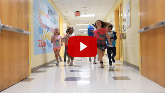 elementary students skipping in hallway