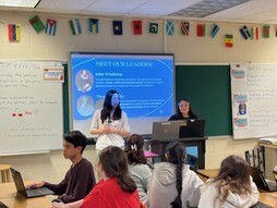 students standing in front of class room giving presentation