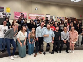 Adults and students standing together in group