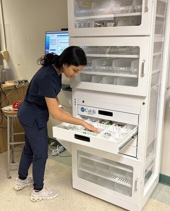 student looking in simulated medication dispensing cabinet drawer