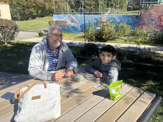An adult has lunch with a student 