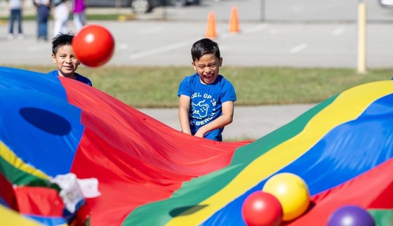 student playing with parachute on field day