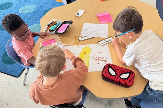 Students working on a drawing and story.