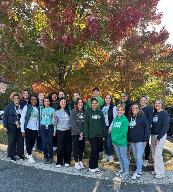  A group of teachers pose for a picture by the tree 