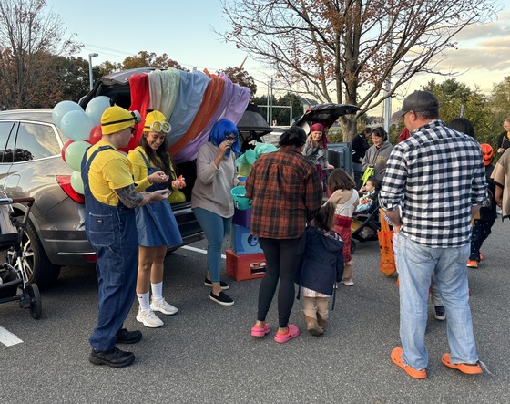 Families hosting trunks and costumed students getting treats