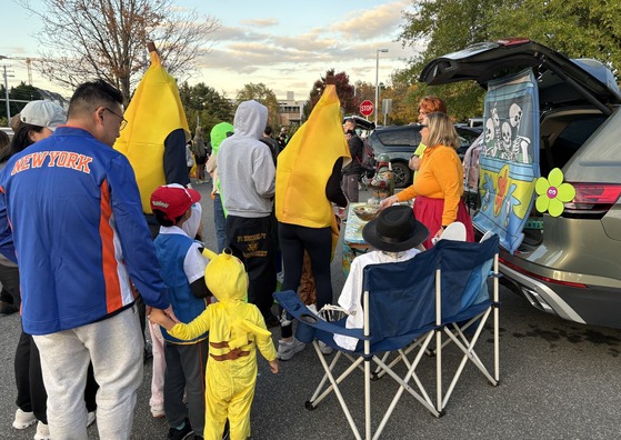 Families hosting trunks and costumed students getting treats