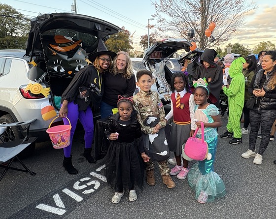 Families hosting trunks and costumed students getting treats